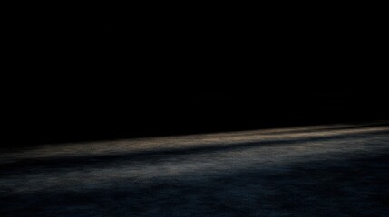 An image displaying a dark room with a visible floor that has subtle lighting and soft shadows.