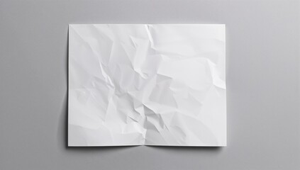 Crumpled white paper sheet with shadows on gray surface, suitable for text background