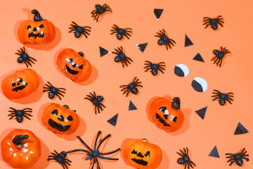 Halloween double border of scattered candy and decor. Flat lay over an orange background with copy space.