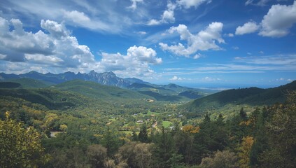 Obraz premium Picturesque landscape featuring hills, mountains, clear blue sky, and lush greenery along a roadside