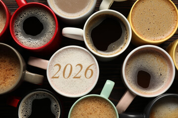 Hello New 2026 Year. Cup of coffee with numbers among others on table, top view