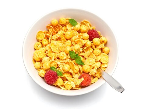 A white bowl filled with breakfast cereal, raspberries, and mint leaves, with a spoon - Powered by Adobe