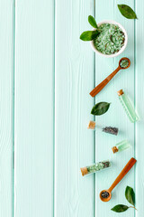 Homemade organic cosmetics products - tea tree essential oil and sea salt with green leaves, top...