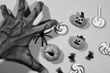 Halloween double frame with black and white theme of scattered candy and decorations. Flat background with copy space.