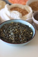 Bowls and bags full of various healthy grains and legumes. Selective focus.