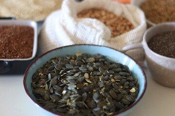 Bowls and bags full of various healthy grains and legumes. Selective focus.