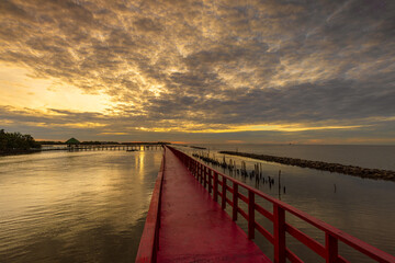 Obraz premium Red wooden bridge in Samut Sakhon Province, a popular tourist attraction in Samut Sakhon Province, Thailand 