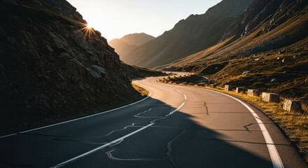 Serpentine mountain road at dawn/dusk with golden sun and shadows