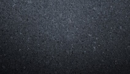Close-up of coarse asphalt texture, dark grey tarmac with grainy surface, overhead perspective