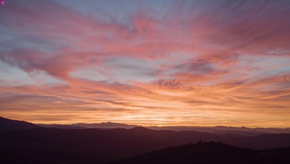 Obraz premium Mountains Silhouetted Against a Cloudy Sunset Sky