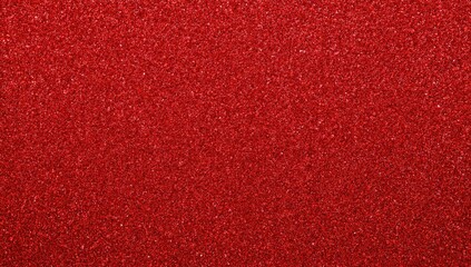 Close-up of a shiny red metallic wrapping paper with glitter on a dark red backdrop