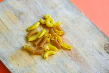 Uncooked elbow macaroni on white background
