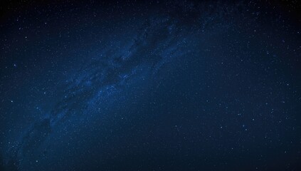 Fototapeta premium Wide-angle view of the Milky Way against a deep blue night sky filled with stars, captured with long exposure and enhanced white balance, featuring noise and grain effects.