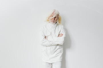 Fashion model in a minimalist white outfit posed against a smooth white background, exuding an...