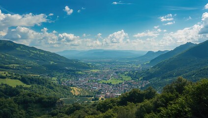 Fototapeta premium Aerial view of a town surrounded by verdant mountains, showcasing seasonal change