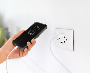 Mobile Phone Charging with USB-C Cable on Multi-Port Power Wall Socket in Modern Living Room