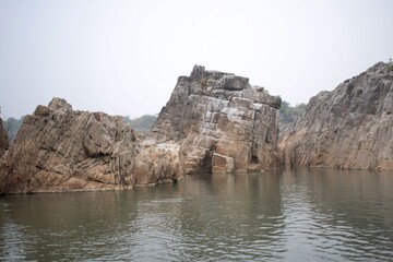 dramatic rocky pink marble cliffs rise above calm river waters, creating a serene and majestic canyon setting