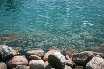 Smooth stones by clear flowing water in the front