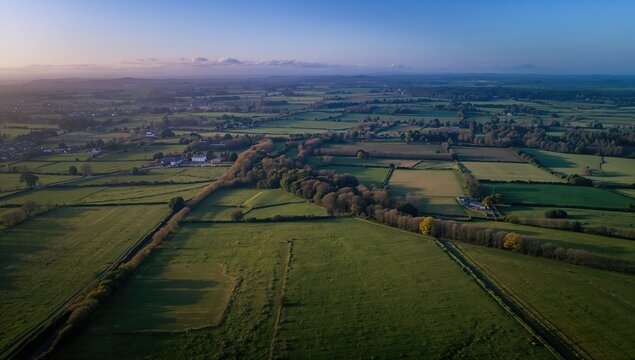 Aerial view of lush green fields and farms in Ireland, showcasing agricultural richness, seasonal change