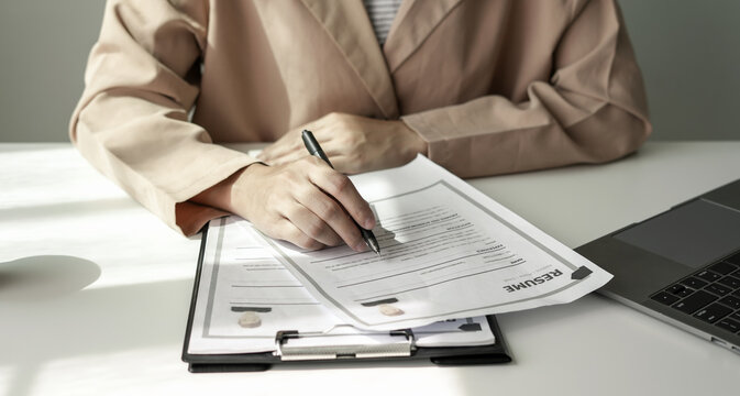 Business woman employer holding resume hiring recruit looking cv resume to hire candidates, analyzing information before job interview. Recruitment concepts