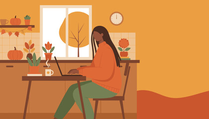 Woman works remotely on laptop in a cozy kitchen setting enjoying the autumn season