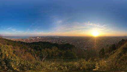 Obraz premium Wide-angle view of the sky, nature, urban landscape, sun, blue tones, and sunset