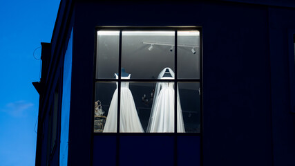 Bridal shop window with wedding dresses at night