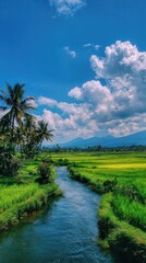 Obraz premium Lush green field with a river, palm trees, mountains, and bright blue sky