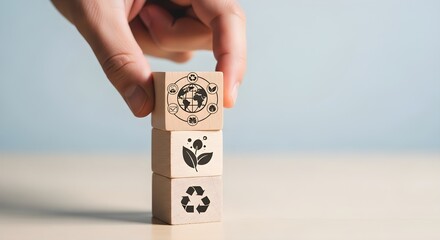 Hand stacking wooden blocks with eco friendly symbols for sustainability