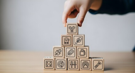 Hand stacking wooden blocks with business and finance icons