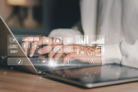 Business professional using laptop to manage smart farming IoT dashboard with AI data analytics, soil sensors, and weather monitoring, representing digital agriculture, automation, and sustainability.