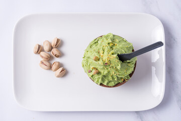 Top view of a bowl of pistachio ice cream on a plate.