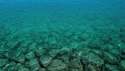 Obraz premium Transparent sea water revealing the rocky bottom, ideal backdrop for UI design