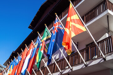 Multiple flags display at a building under a clear blue sky