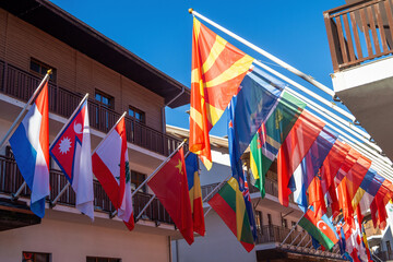 Flags from around the world displayed on a sunny day in a vibrant market