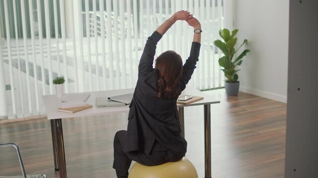 Sustainable Office and Employee Wellness. Businesswoman Stretches on Fitness Ball at Desk, Promoting Green Workplace, Eco Lifestyle, Active Posture, Work Life Balance and Healthy Corporate Culture