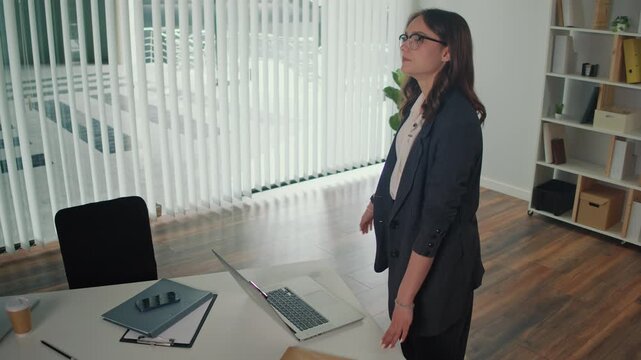 Mindfulness at Work and Employee Wellbeing. Office Manager Performs Standing Quadriceps and Lumbar Spine Stretch at Desk to Improve Posture, Reduce Tension, Boost Focus and Support Healthy Workplace