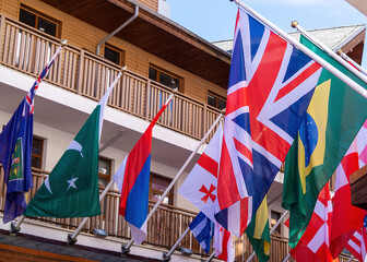 Colorful display of international flags adorning a charming street in a mountain resort area