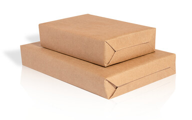 Two rectangular boxes wrapped in kraft paper lying on top of each other on a white background with...