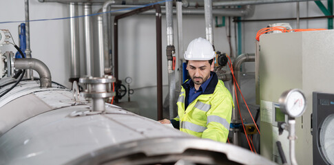 Engineers or utility staff wearing safety helmet fix the machines in the production line. Utility...