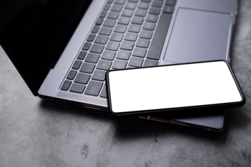 Phone screen mockup laying on laptop desktop.