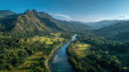 A beautiful landscape shows a river gracefully flowing through vibrant greenery and rolling hills.