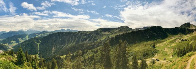 Panoramic mountain view surrounded by lush greenery under a bright blue sky