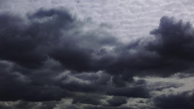 Time lapse of dramatic storm clouds moving across the sky with sunlight rays breaking through. 4K