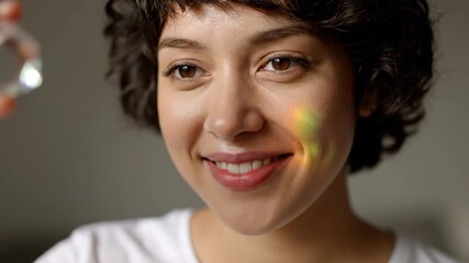 A joyful woman with a radiant smile is touched by a beautiful spectrum of light. - Powered by Adobe