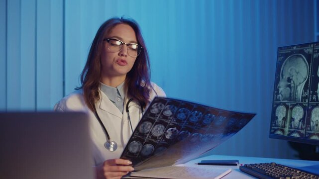 Breakthrough Research. Female Doctor Holds Brain MRI Scans During A Medical Report Presenting New Findings On Stroke Diagnosis And Treatment