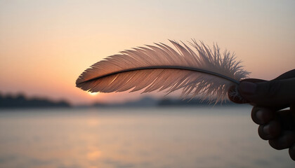 Close-up of a White Feather Held in Hand Silhouetted Against a Golden Sunset Over Calm Water for Concepts of Freedom, Lightness, and Serenity