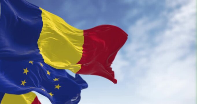 Romania and European Union flags waving in the wind on a clear day