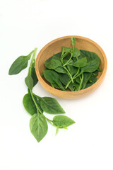 Basella alba - leaf vegetable in wooden bowl on white background
