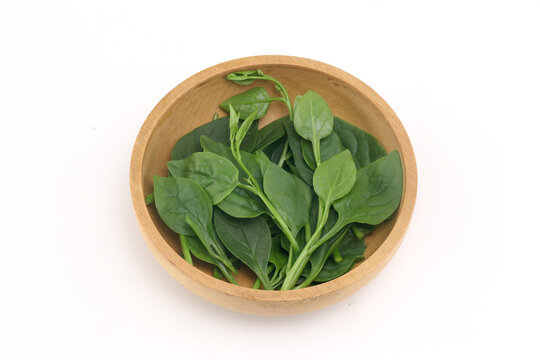 Basella alba - leaf vegetable in wooden bowl on white background